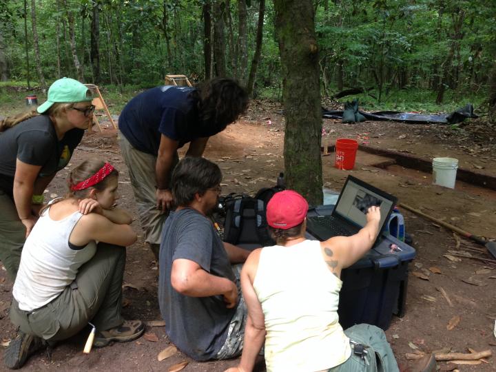 Dr. Birch and field school students look at geophysical data from Singer-Moye