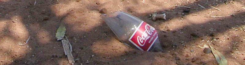 Picture of a broken coke bottle in the sand