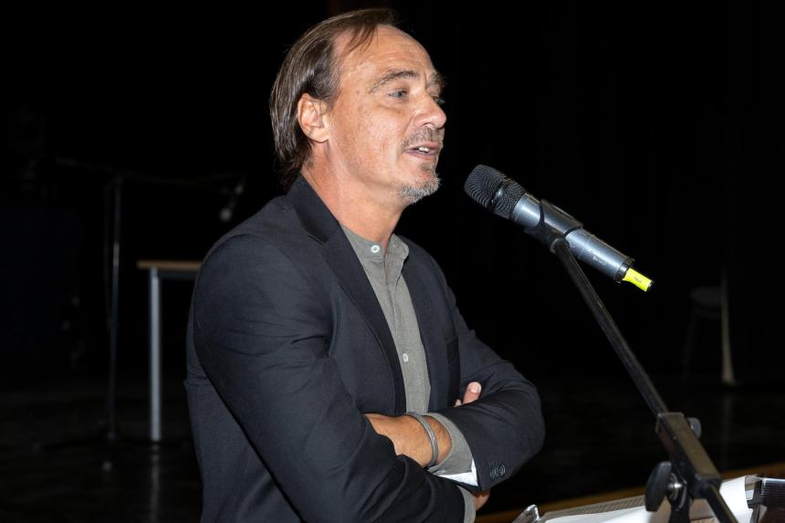 Dr Gyucha speaking into a microphone