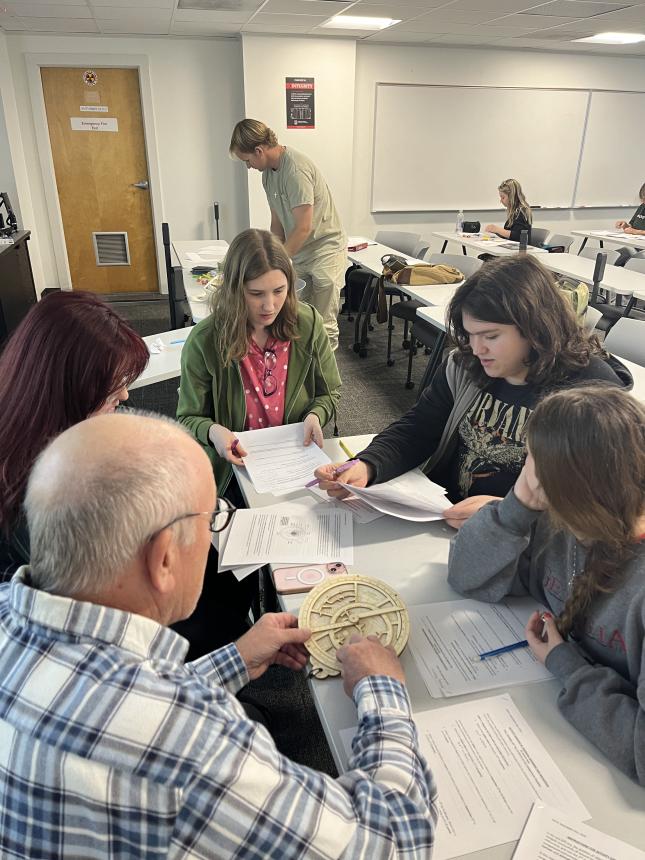 students work in groups in the classroom on medieval navigation instruments