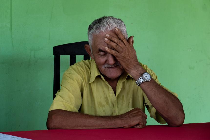 a man sitting in frotn of green wall