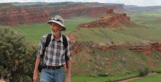 Archaeologist Robert Kelly stands before dramatic mesas