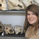 Suzanne Pilaar Birch stands in front of a shelf holding animal skulls
